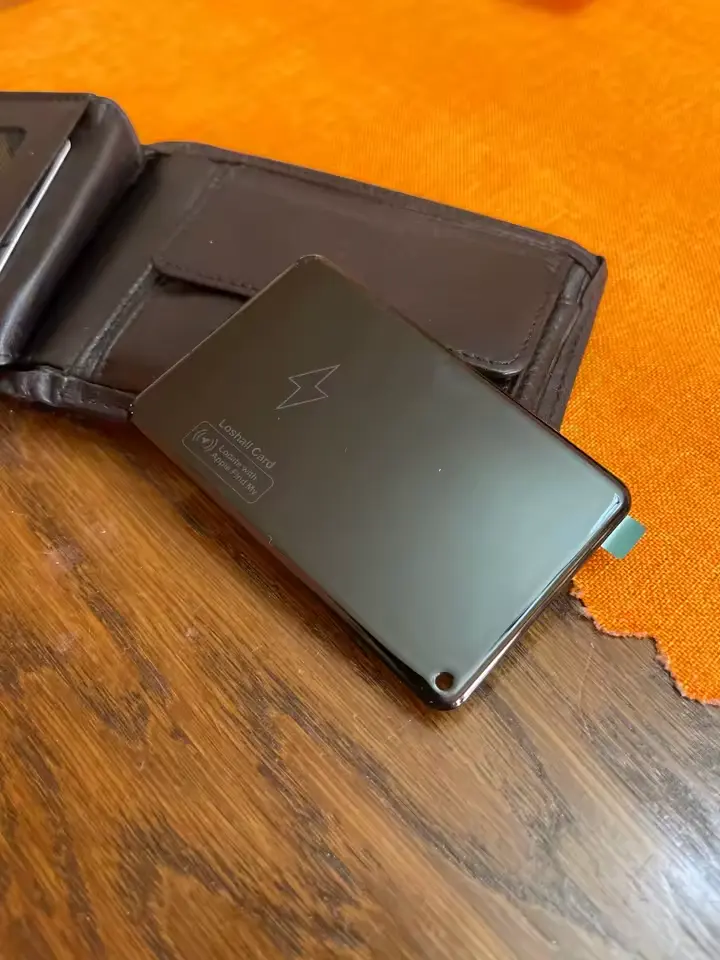 FindCard Pro next to a brown leather wallet