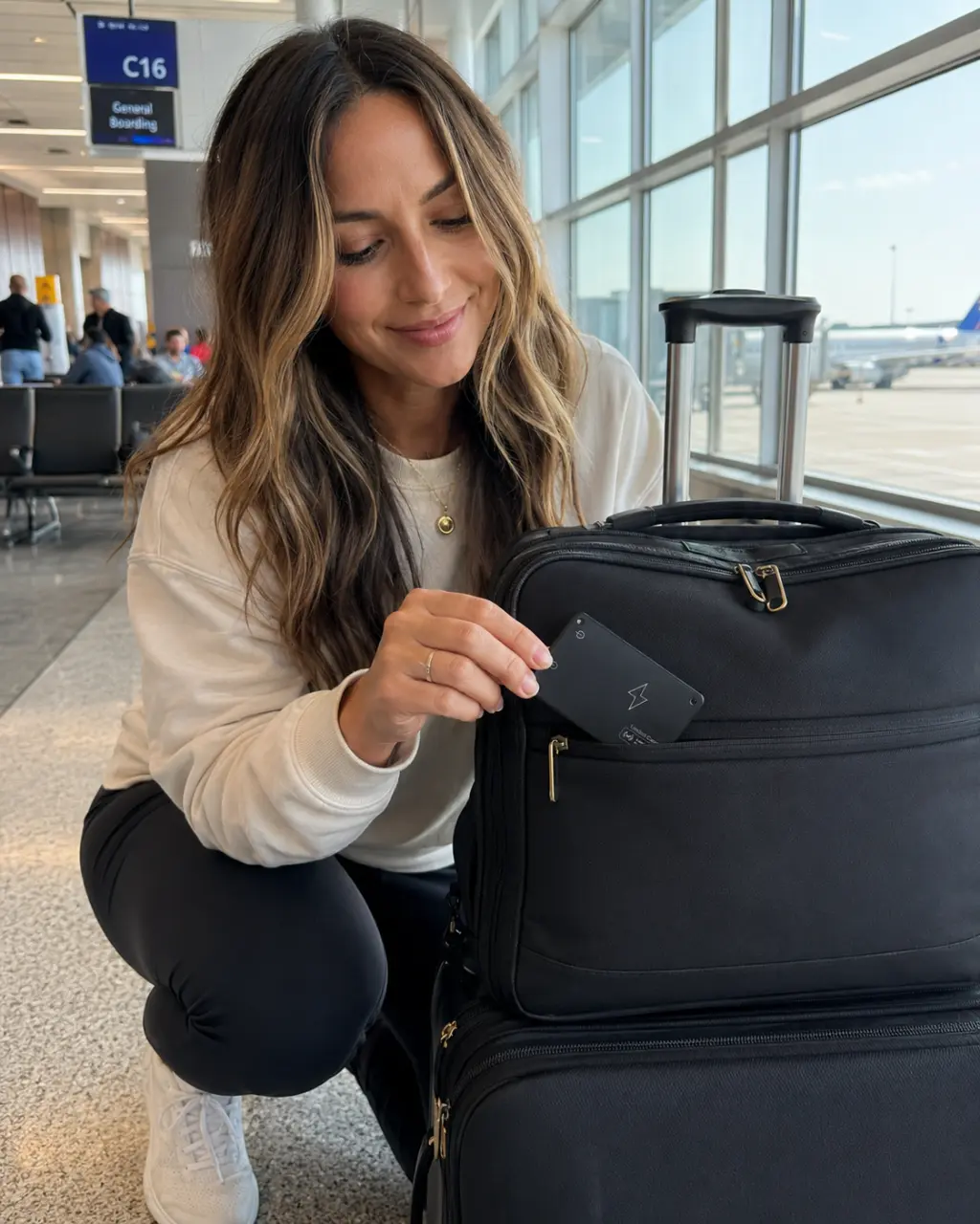 Woman putting FindCard Pro into a laptop bag at the airport